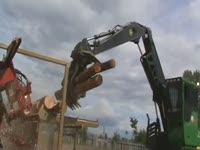Loader loading logs on Twin-Cut Portable Sawmill